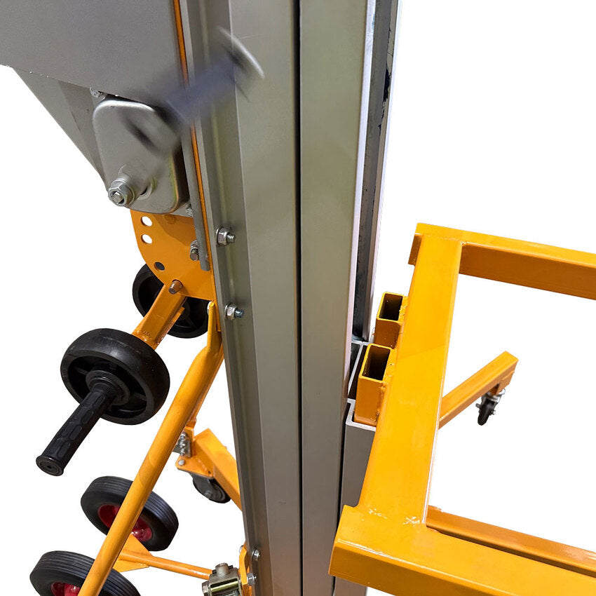 Close-up of a yellow and silver mechanical lift, showcasing its metal framework, wheels, and crank handle for height adjustment.