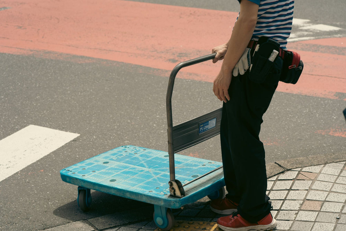 Worker pushing a folding platform trolley