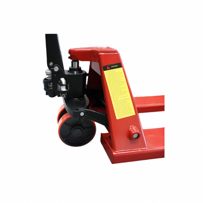 Close-up of a red pallet jack's hydraulic lift mechanism, featuring wheels, a handle, and safety warning labels.