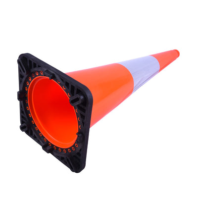 Close-up of an orange traffic cone with a black base and reflective stripe, angled to show its hollow interior.