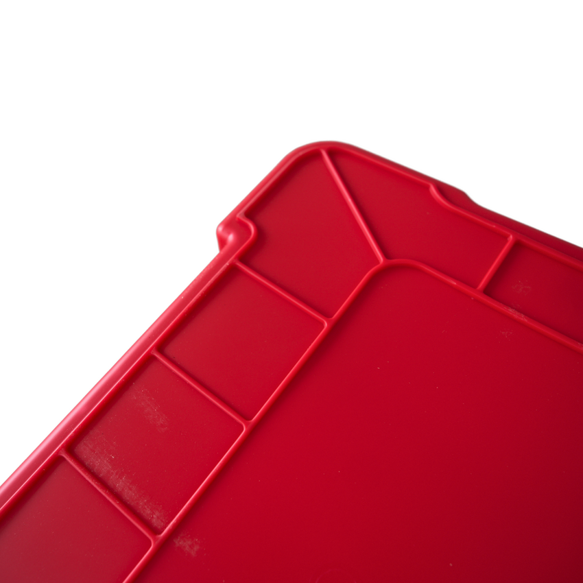 Close up of a red storage container upside down showcasing the ribbed grip underneath.