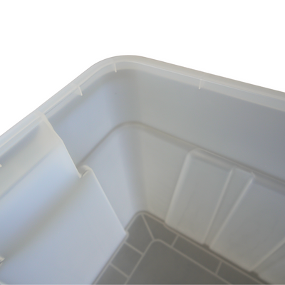 Close-up of a clear plastic storage container, showcasing its smooth corners and bottom design with grid patterns.