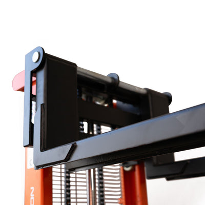 Close-up of a pallet stacker's black metal forks raised fully, designed for lifting and moving materials.